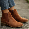 Brown brushed-finish Chelsea boots with elastic gore panels, side zip, and a low stacked heel worn with cropped denim.