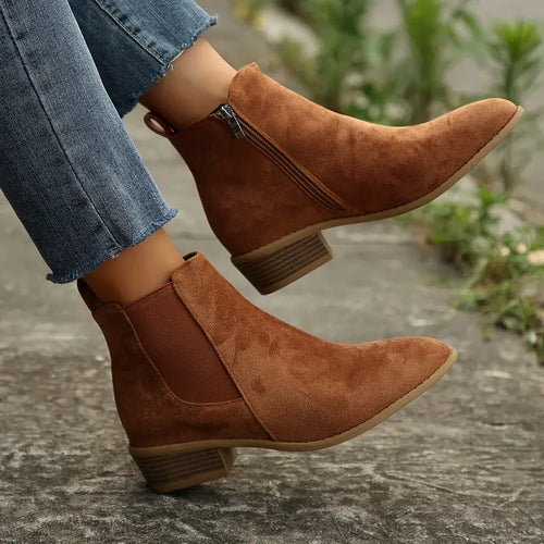 Brown brushed-finish Chelsea boots with elastic gore panels, side zip, and a low stacked heel worn with cropped jeans.