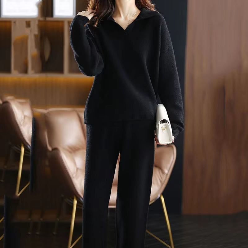 Black ribbed knit V-neck sweater with a folded collar, long sleeves, and a straight-cut hip-length hem.