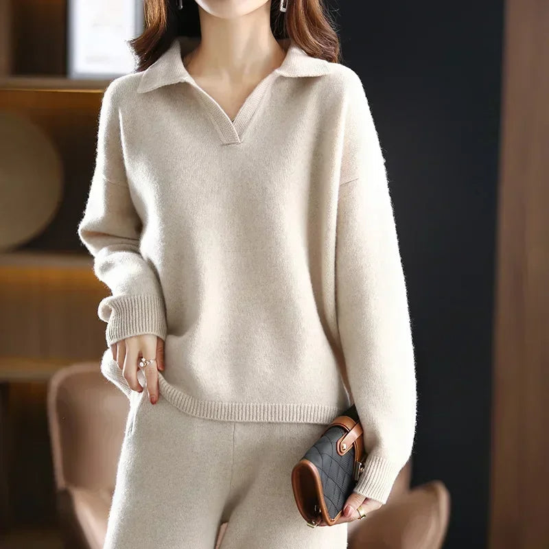 Beige V-neck sweater with a folded collar, vertical knit texture, and wide ribbed cuffs in a hip-length straight fit.