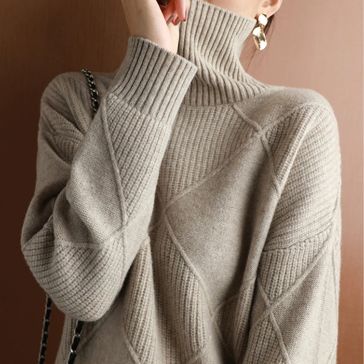 Beige wool turtleneck sweater featuring a raised diamond-pattern knit, ribbed collar, and cuffs in a relaxed fit.