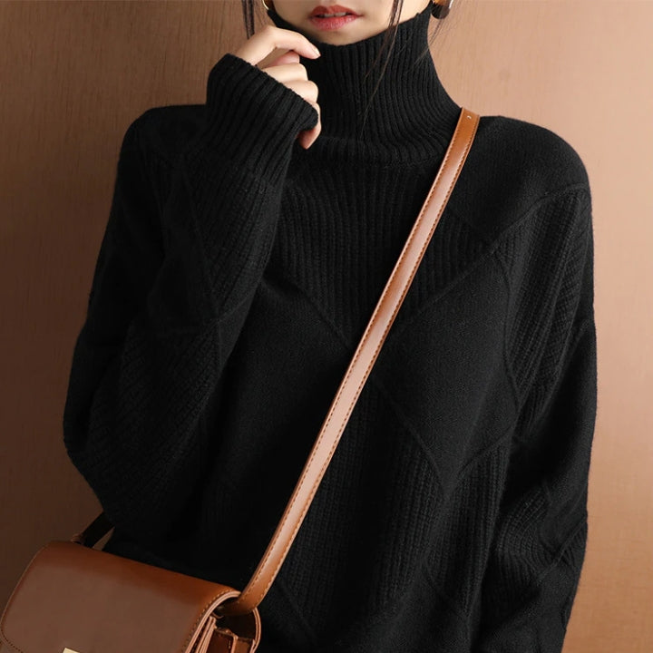 Black wool turtleneck sweater featuring a raised diamond-pattern knit, ribbed cuffs, and a high collar.