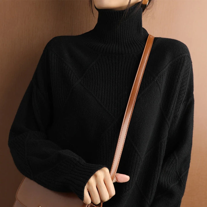 Black wool turtleneck sweater featuring a raised diamond-pattern knit, high ribbed collar, and relaxed fit.