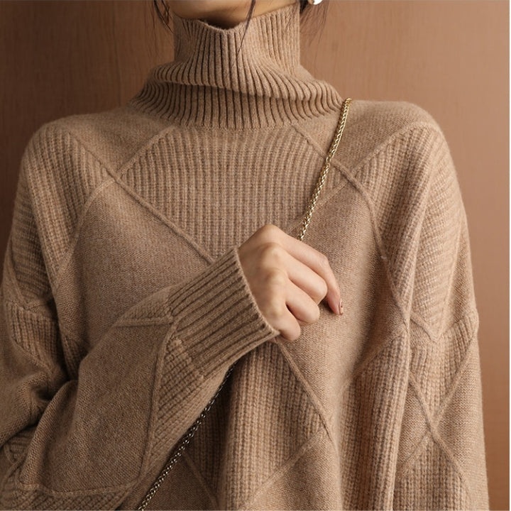 Tan wool turtleneck sweater featuring a raised diamond-pattern knit, ribbed high collar, and structured cuffs.