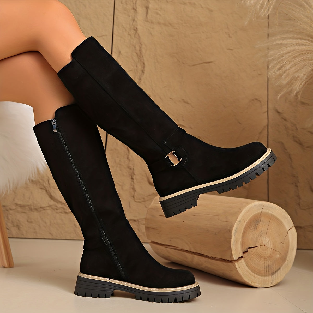 Black knee-high boots with napped shaft, chunky lug sole, stitched welt trim, and side ankle buckle.