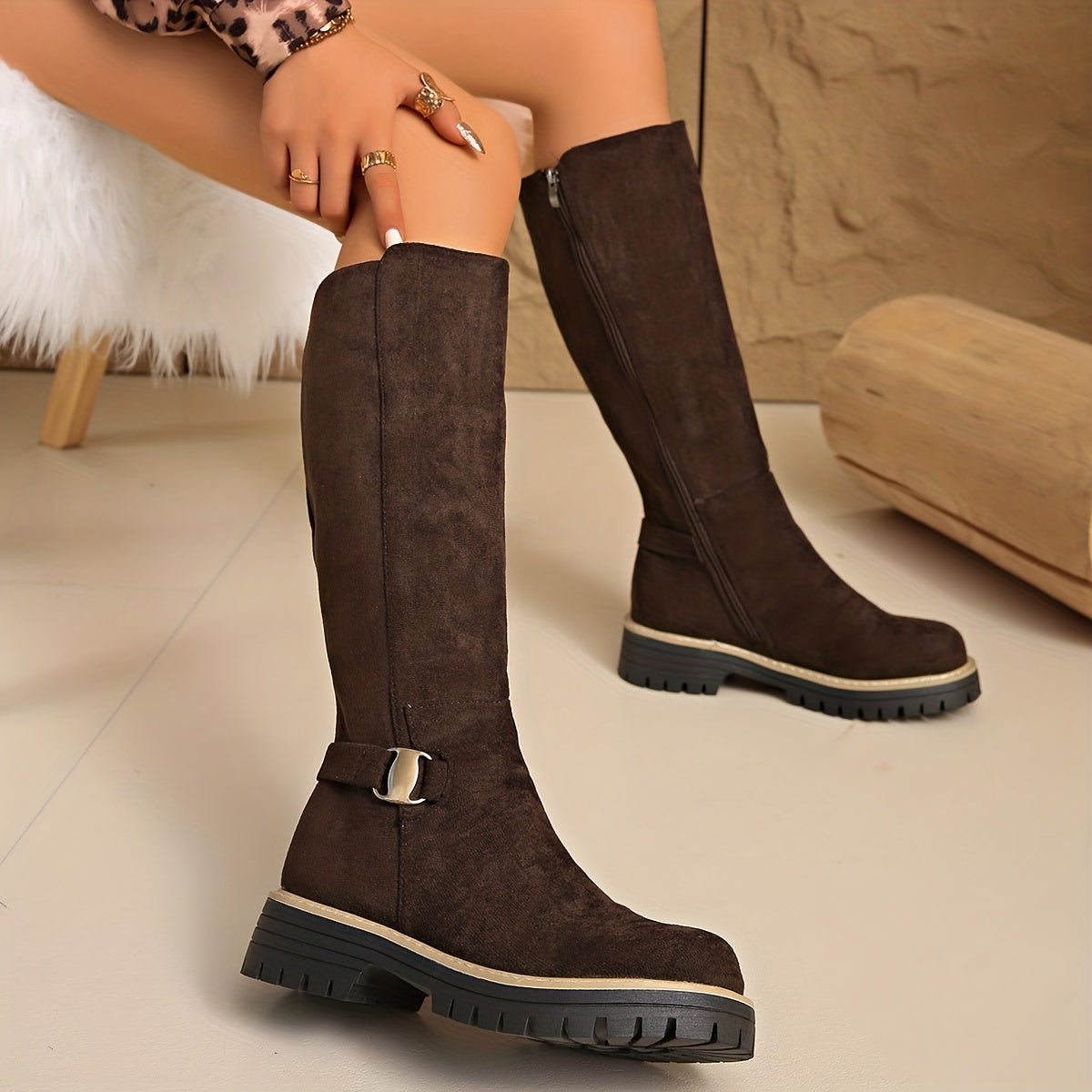 Dark brown napped knee-high boots with a chunky lug sole, stitched welt trim, and a small ankle buckle.