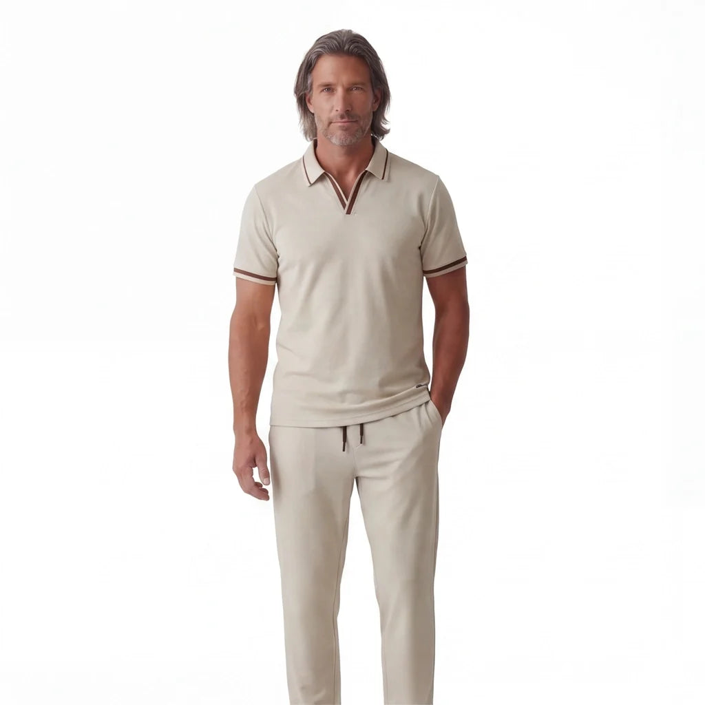 Man wearing a cream short-sleeve polo shirt with matching drawstring pants in a relaxed full-body pose.