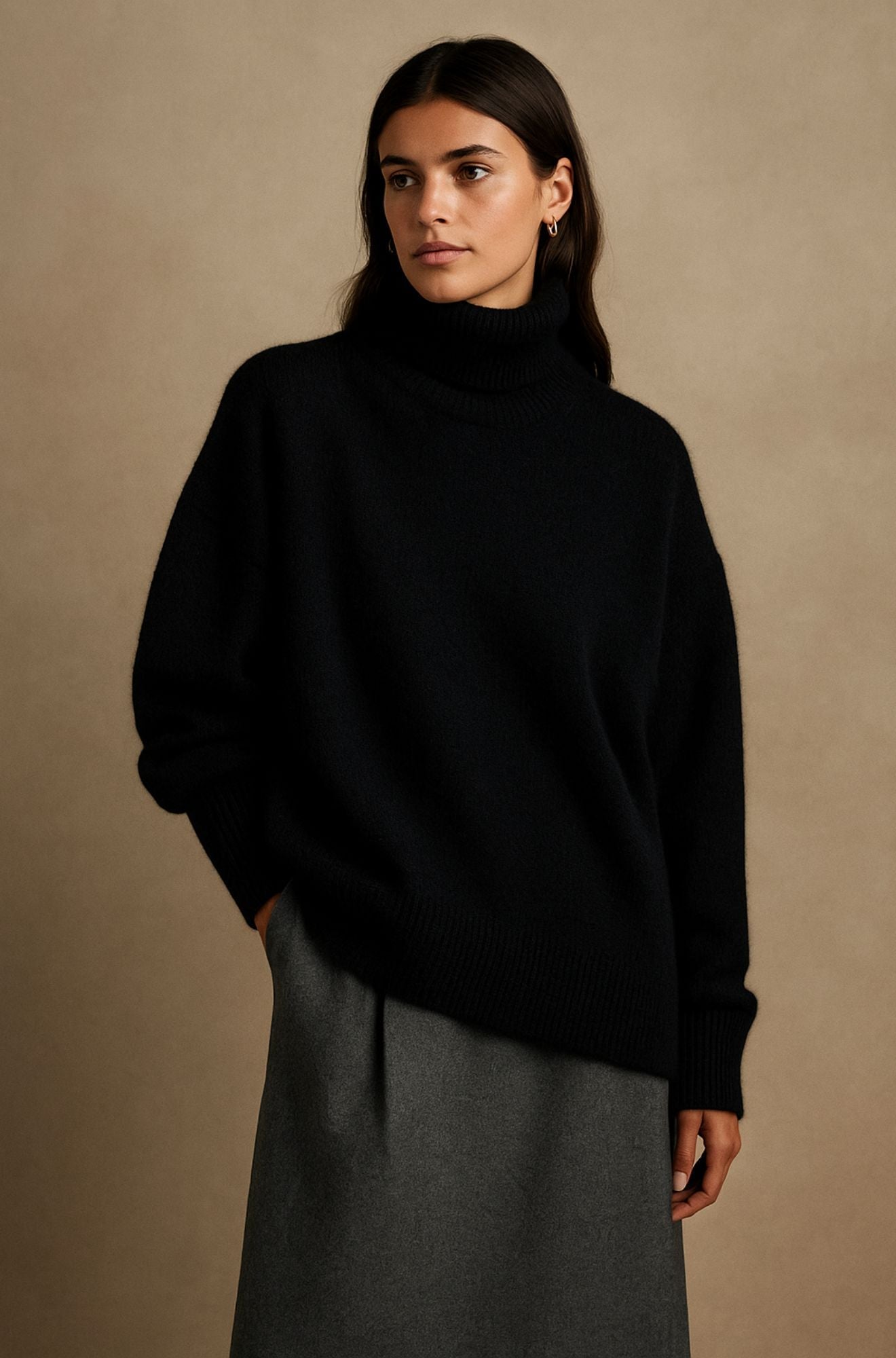 Black oversized turtleneck sweater with a relaxed fit, dropped shoulders, and ribbed cuffs, paired with a gray skirt.