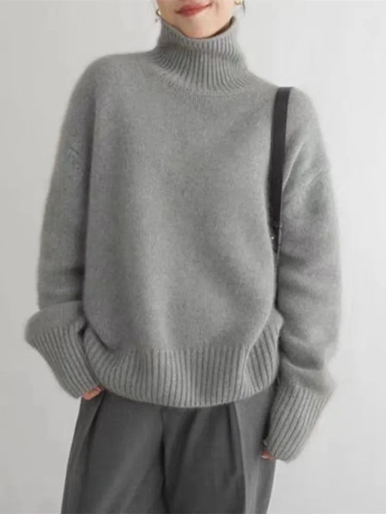 Grey brushed knit turtleneck sweater with a relaxed oversized fit, high ribbed collar, and wide ribbed cuffs.