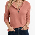 Dusty rose ribbed knit henley sweater with a half-button placket, relaxed fit, and long sleeves in a soft texture.