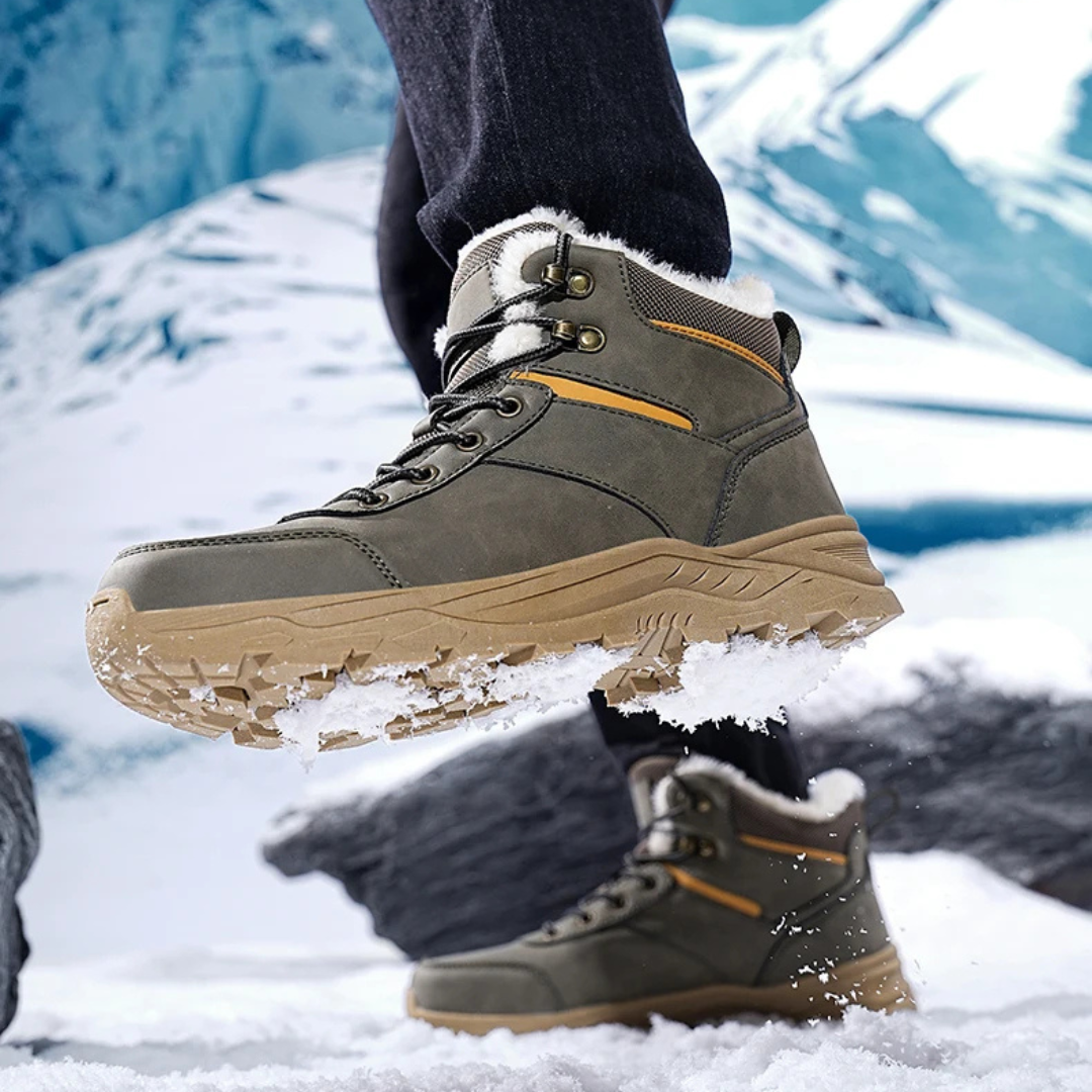 Gray ankle snow boots for men mid-step on ice, showing the deep lug sole tread