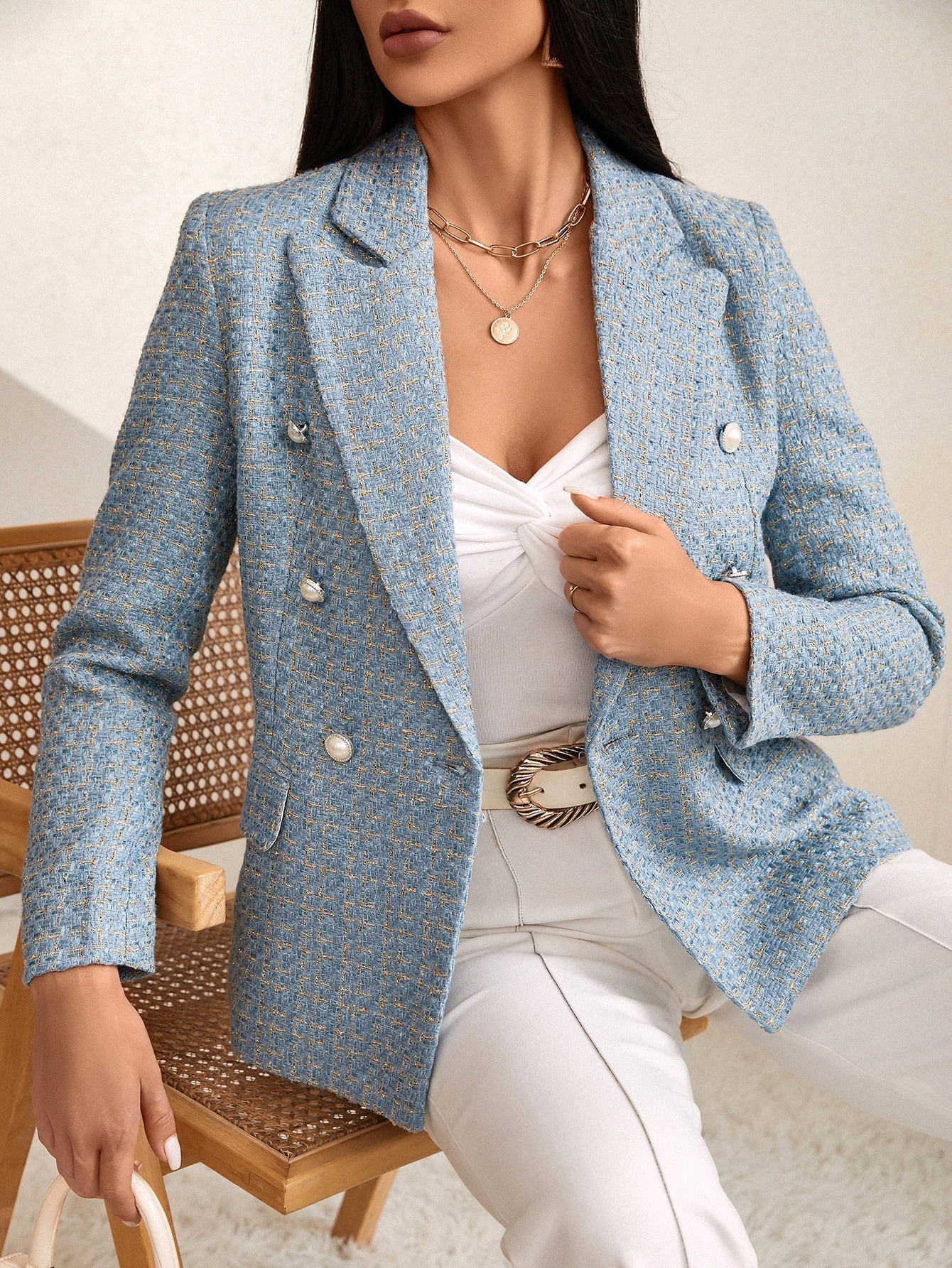 Blue tweed double-breasted blazer with notched lapels and decorative buttons, worn over a white top and trousers.