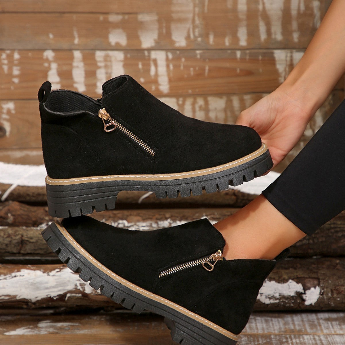 Black brushed-finish ankle boots with side zips, round toes, and thick notched tread platform soles.