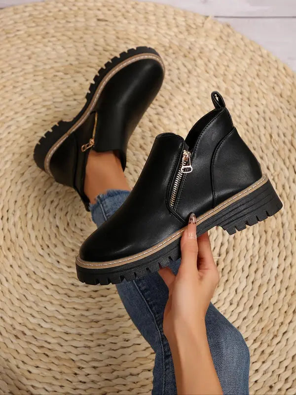 Black brushed-finish ankle boots with side zips, round toes, and chunky notched tread platform soles.
