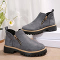 Grey brushed-finish ankle boots with side zips, round toes, and thick black notched tread platform soles.