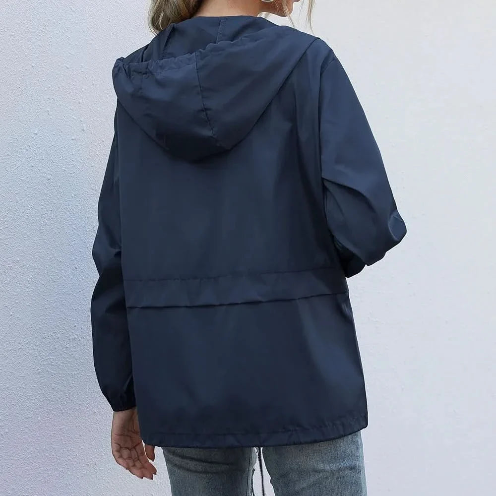 Back view of a navy hooded lightweight windbreaker jacket with long sleeves and a relaxed fit.