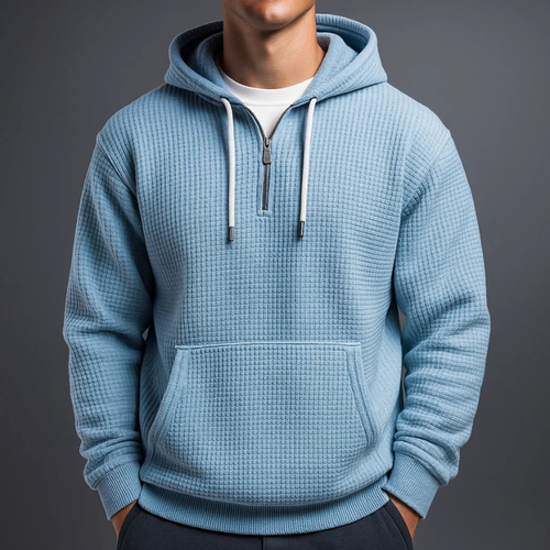 Light blue waffle knit pullover hoodie featuring a kangaroo pocket, adjustable drawstrings, and a relaxed fit, worn with jeans.
