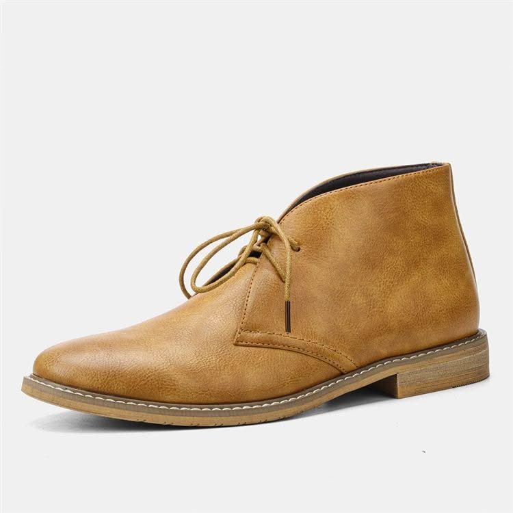 Tan grained leather chukka boots featuring a three-eyelet lace-up design, visible welt stitching, and a low stacked heel.