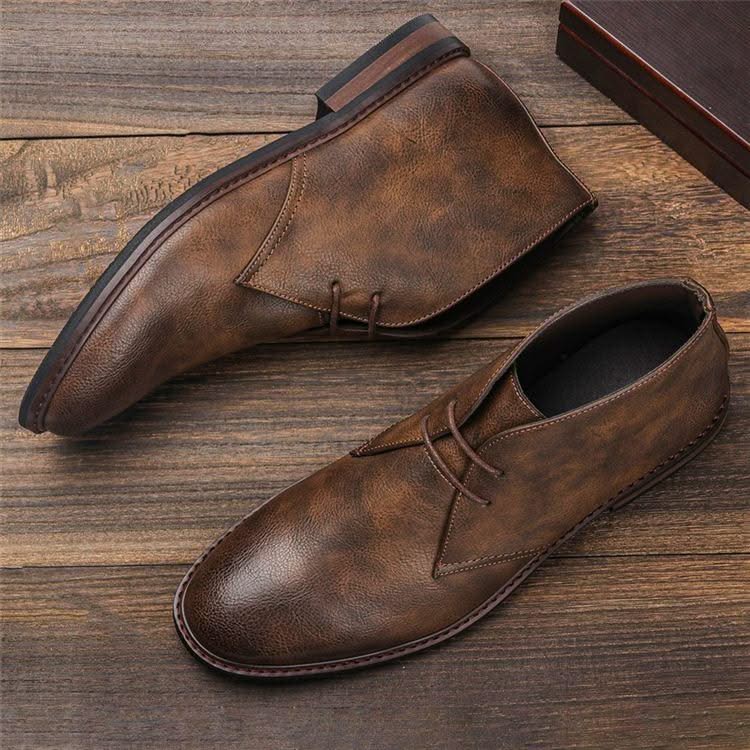 Brown grained leather chukka boots with three-eyelet lacing, visible welt stitching, and a low stacked block heel.