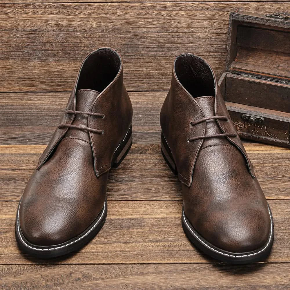 Dark brown grained leather chukka boots with three-eyelet lacing, contrast welt stitching, and a low stacked heel.