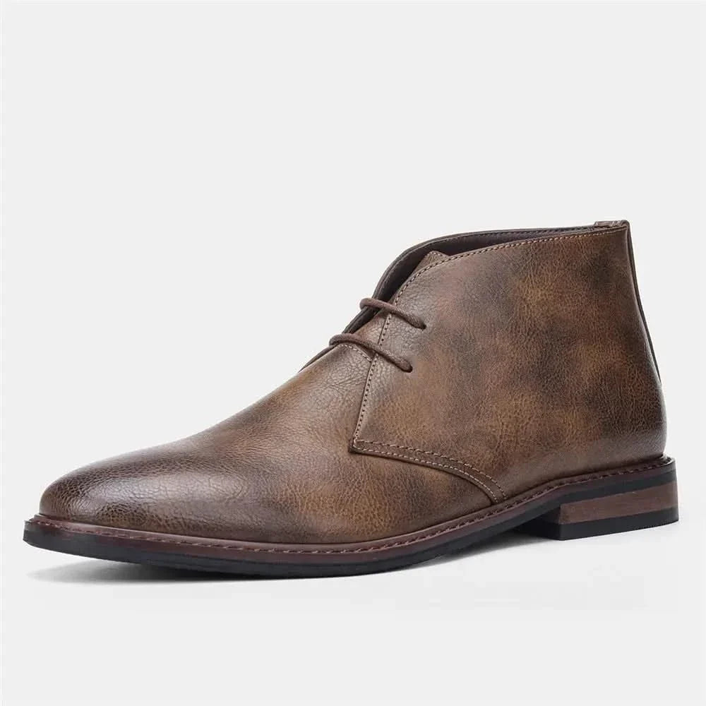 Brown grained leather chukka boots featuring a three-eyelet lace-up design, visible welt stitching, and a low stacked heel.