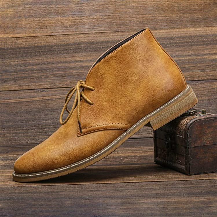 Tan grained leather chukka boot with three-eyelet lace-up closure, visible welt stitching, and a low stacked block heel.