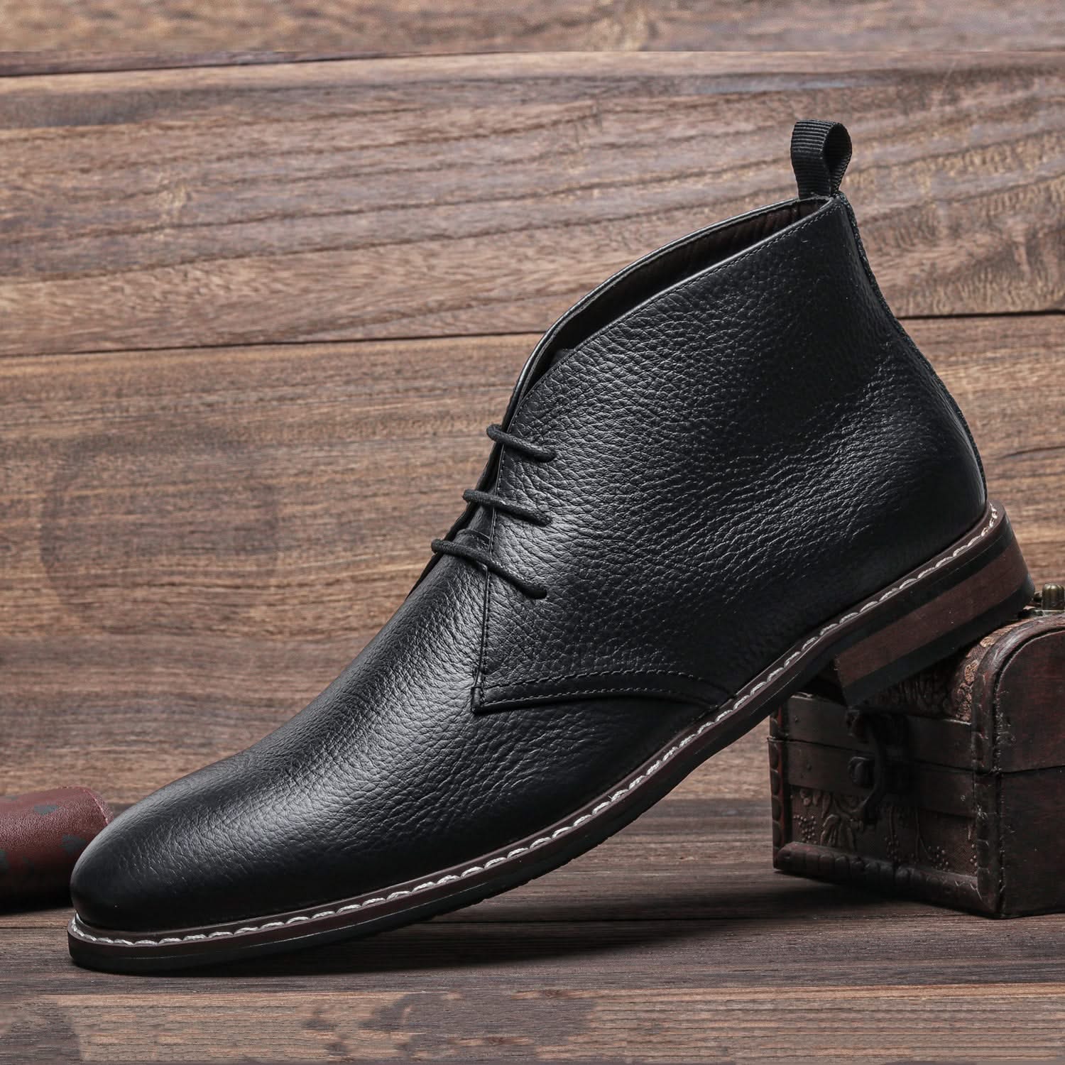 Black grained leather chukka boot with three-eyelet lacing, visible welt stitching, and a stacked block heel.