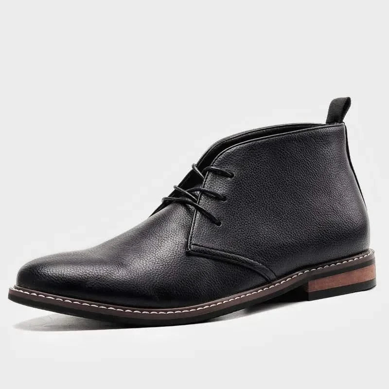 Black grained leather chukka boots with three eyelets, visible welt stitching, and a low stacked block heel.