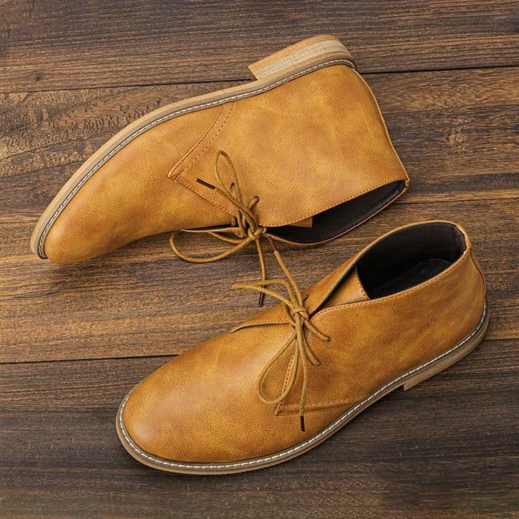 Tan grained leather chukka boots with three-eyelet lace-up closure, visible welt stitching, and a low stacked block heel.