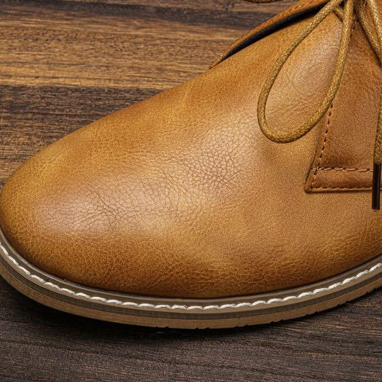 Tan grained leather chukka boot featuring a clean toe line, three-eyelet lace-up closure, and visible white welt stitching.