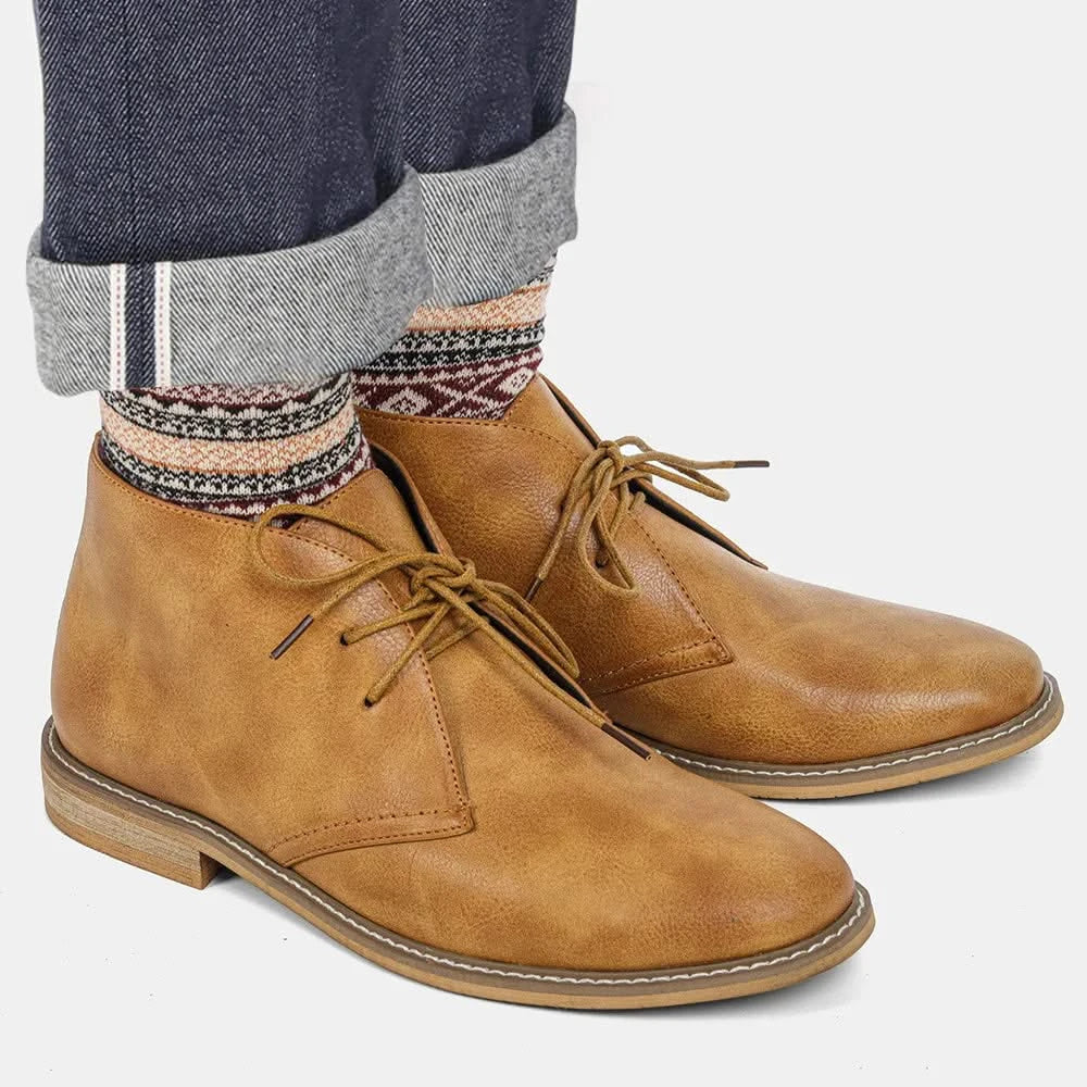 Tan grained leather chukka boots featuring three-eyelet lacing, visible welt stitching, and a stacked low block heel.
