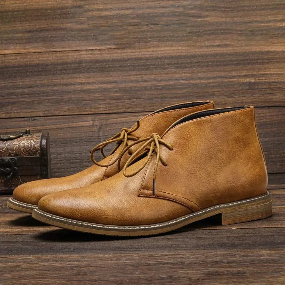 Tan grained leather chukka boots with three-eyelet lace-up closure, visible welt stitching, and a low stacked block heel.