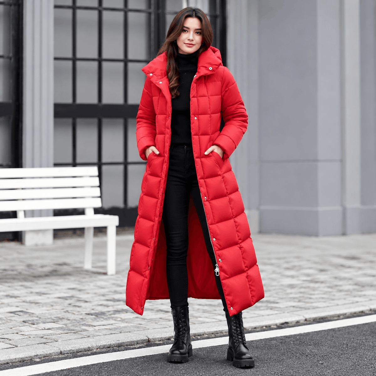 Red maxi puffer coat with box quilting, snap placket, and hood, worn over black separates with a cinched belted waist.