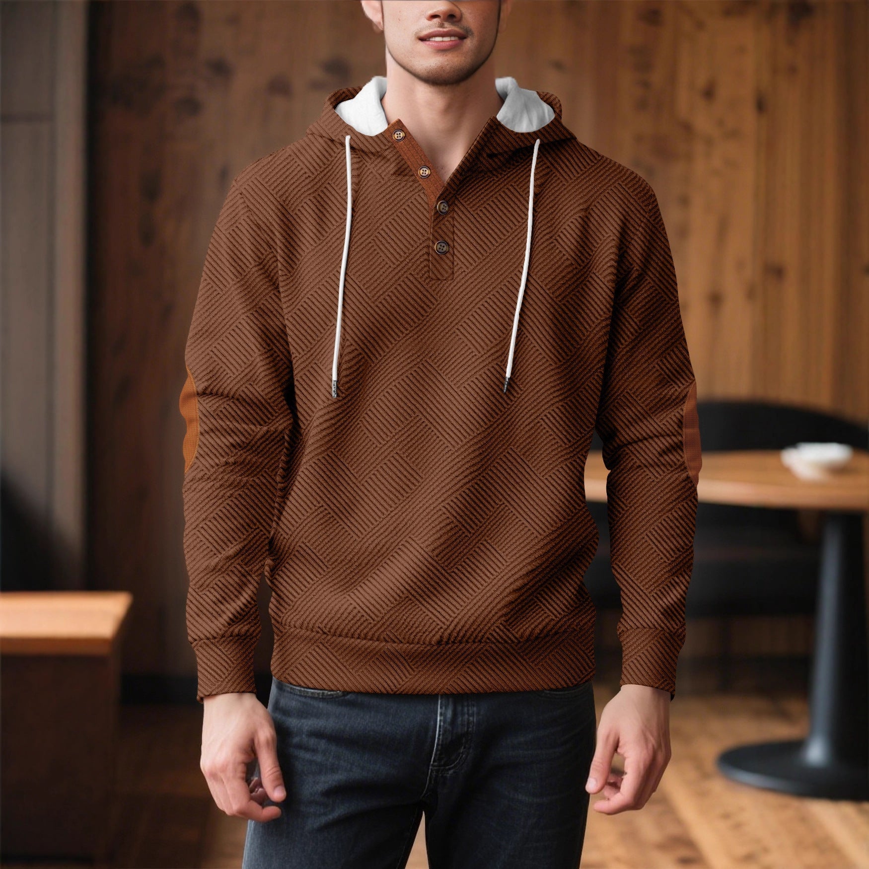 Brown waffle knit pullover hoodie with a button placket, contrast drawstrings, and long sleeves, worn with dark jeans in a cozy indoor setting.