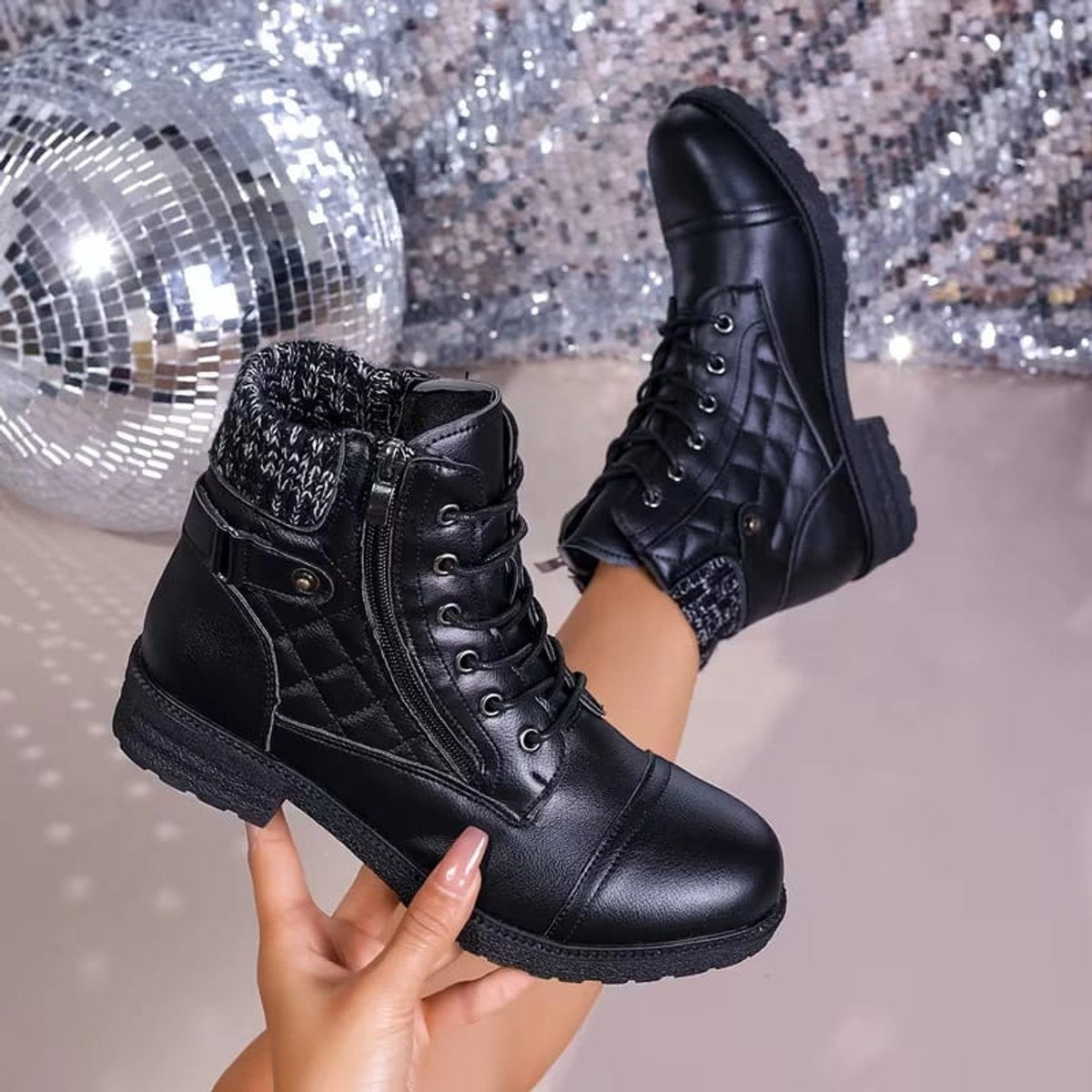 Black quilted ankle boots featuring a ribbed knit cuff, lace-up front, side zip, and a low block heel.