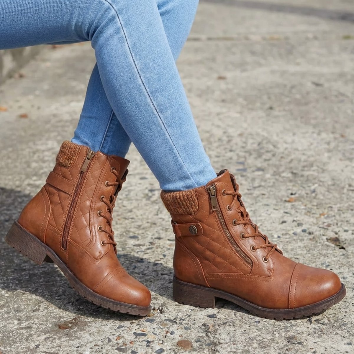 Tan quilted ankle boots with ribbed knit cuffs, side zippers, and lace-up fronts worn with light blue denim jeans.