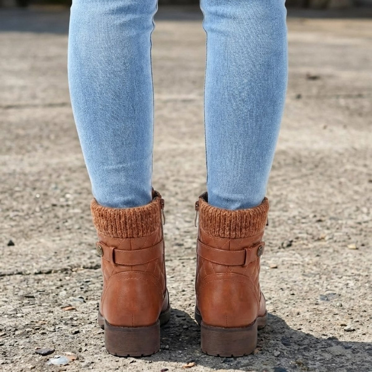 Tan quilted ankle boots featuring a ribbed knit cuff, side zip, and low block heel worn with light wash denim jeans.