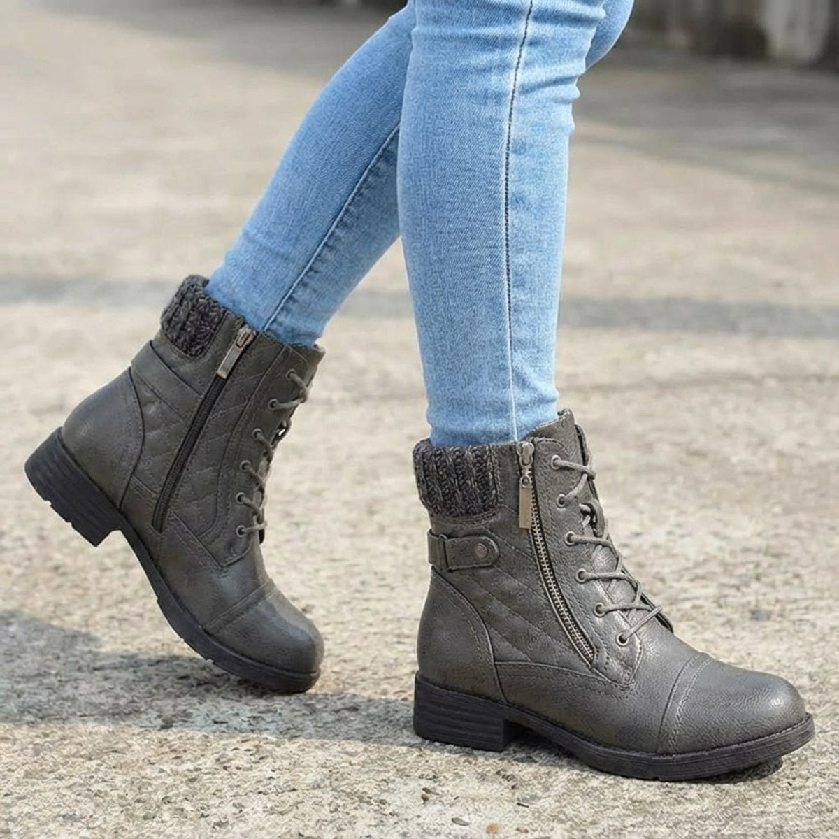 Grey quilted ankle boots with ribbed knit cuffs, side zip, front laces, and a low block heel worn with blue jeans.