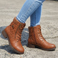 Tan quilted ankle boots featuring a ribbed knit cuff, lace-up front, side zip closure, and a low block heel.