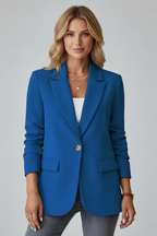 Royal blue tailored blazer with notched lapels, single-button closure, and structured shoulders over grey denim.