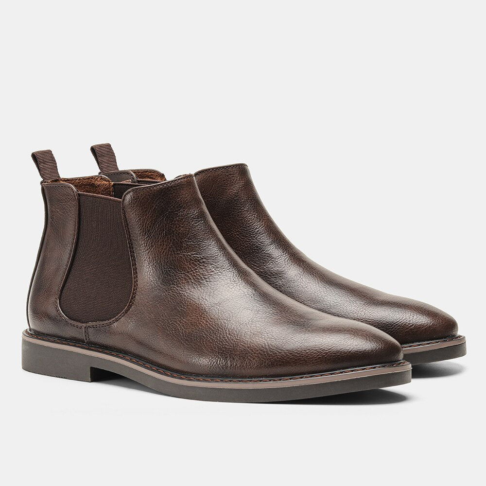 Dark brown leather Chelsea boots featuring a round toe, elastic side gores, dual pull tabs, and a stitched welt sole.