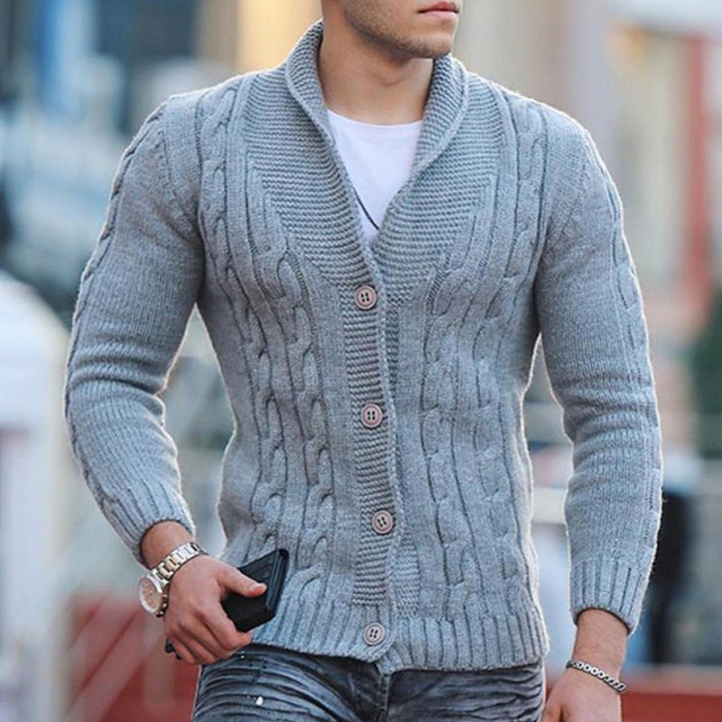 Grey cable knit shawl collar cardigan with a button-front closure and ribbed cuffs worn over a white tee.