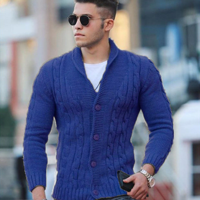 Blue cable knit shawl collar cardigan with a button-front closure and ribbed cuffs worn over a white t-shirt.