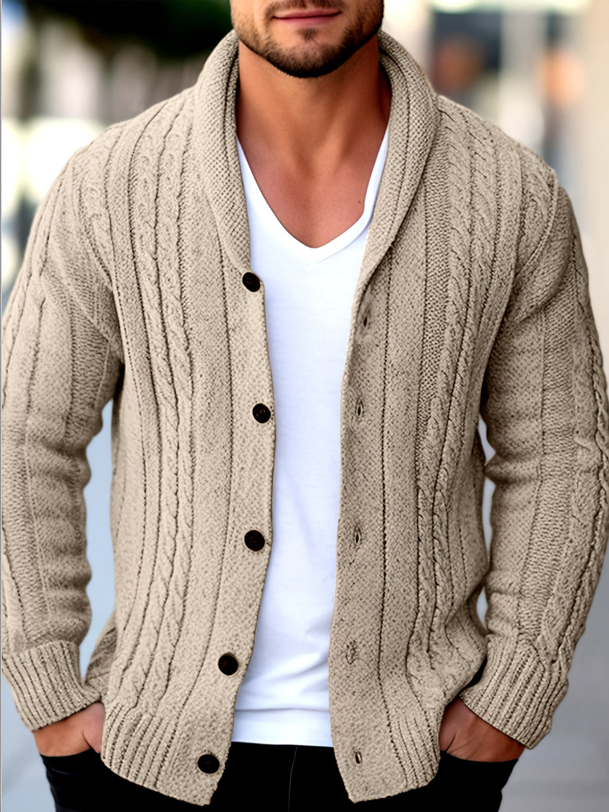 Beige cable knit shawl collar cardigan with a button-front closure, worn open over a white v-neck t-shirt.