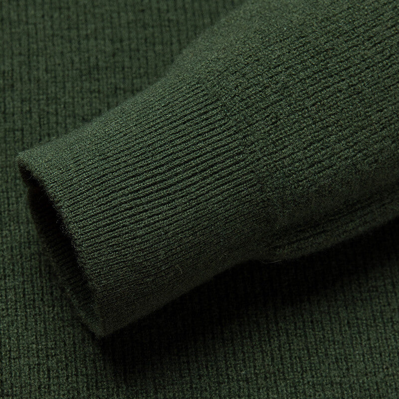 Close-up of the forest green knit sweater ribbed sleeve cuff showcasing the premium knit texture.