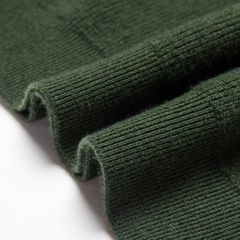 Close-up of the forest green knit sweater ribbed hem highlighting the soft knit construction.