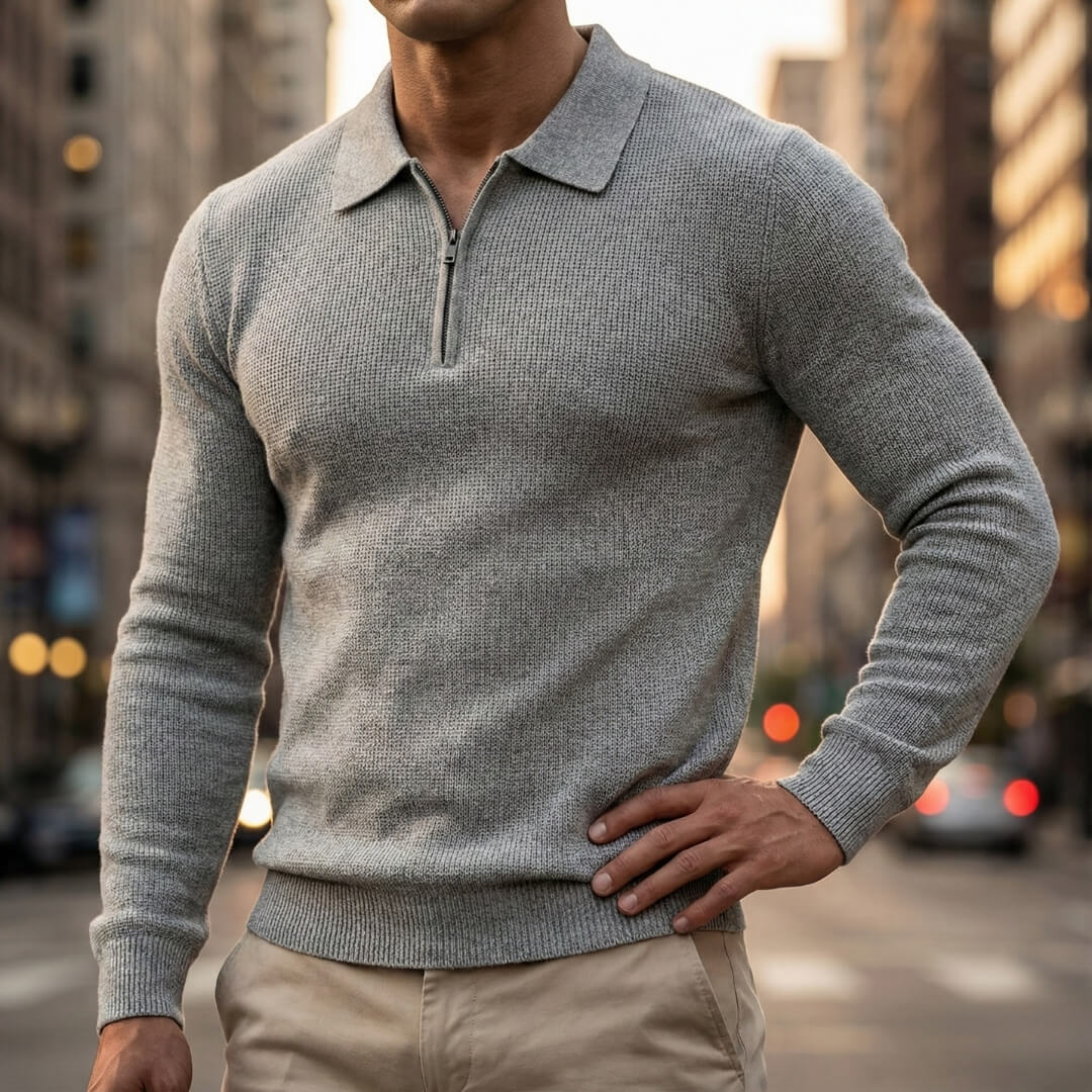 Light gray quarter-zip knit polo sweater featuring a ribbed collar and long sleeves, styled with beige trousers outdoors.