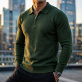 Forest green quarter-zip knit polo sweater with a ribbed collar, long sleeves, and ribbed hem, worn in a city setting.