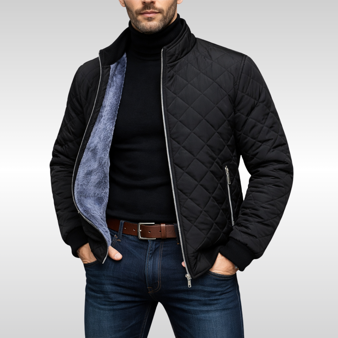 Man wearing a black diamond-quilted insulated jacket with a stand collar, fleece lining, and black turtleneck sweater.