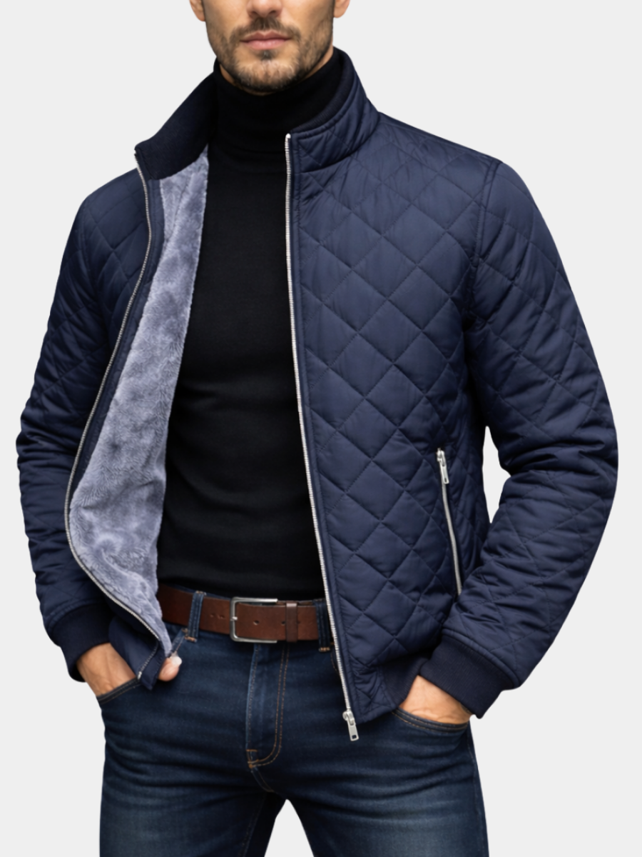 Man wearing a navy quilted insulated jacket with a stand collar, full-zip front, and soft fleece lining.